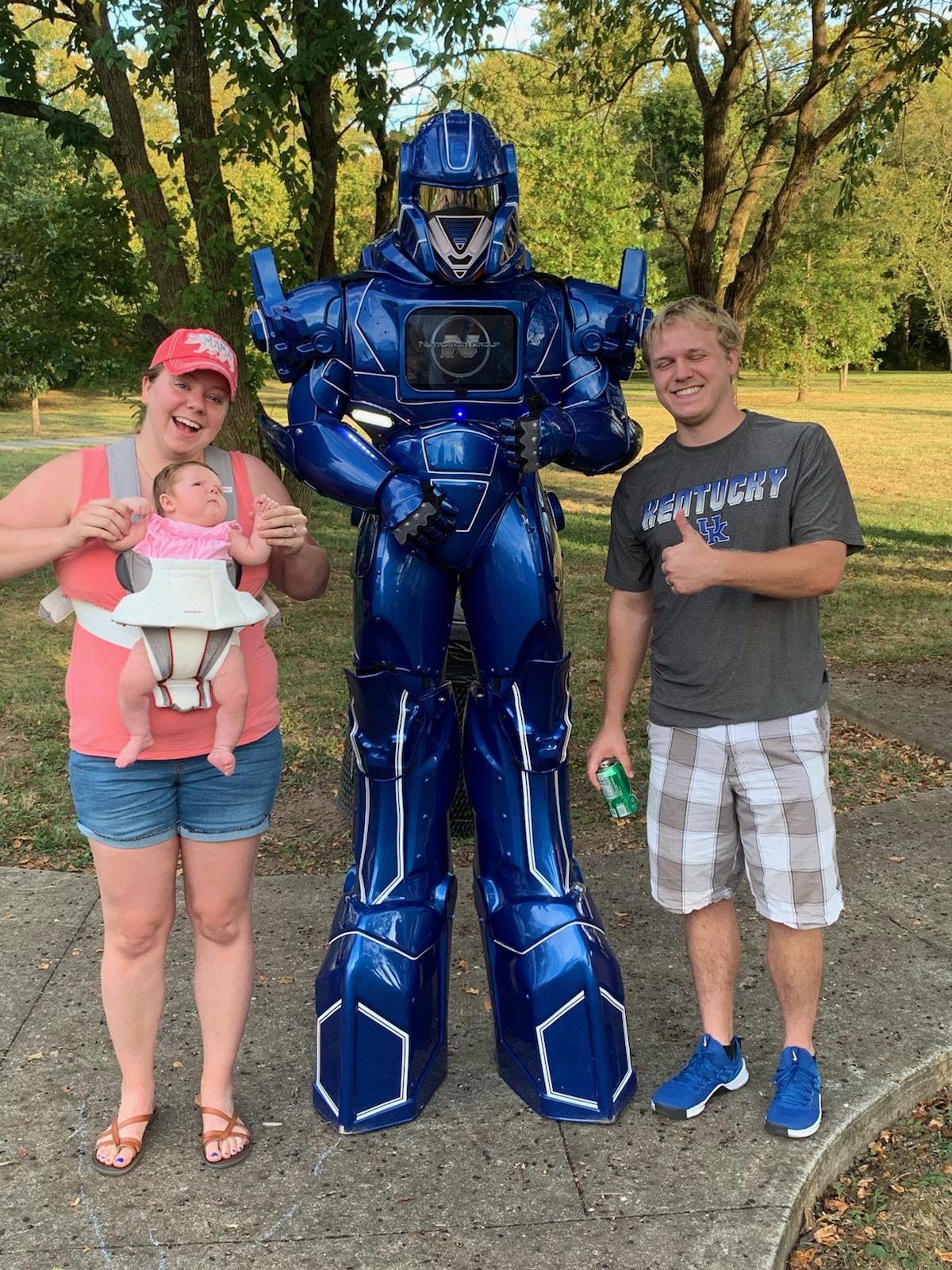 two goofs posing with the robot, and a cute baby